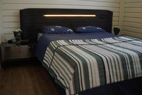 a bedroom with a large bed with a striped blanket at ON2 Bungalov Villas in Dosemealti