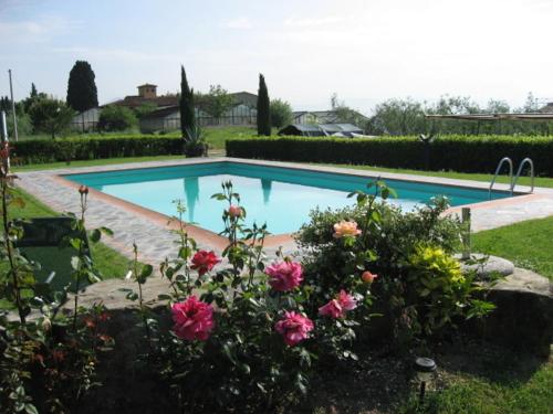 una piscina con fiori rosa in un cortile di Agriturismo Villani Poderi Nesti & Cupoli a Lastra a Signa