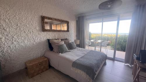 a bedroom with a bed and a window with a table at Beautiful sea view studio in Lumio