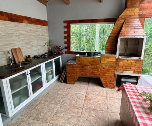 a kitchen with a brick stove and a sink at Pousada Tia Moni in Blumenau