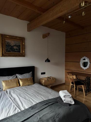 a bedroom with a large bed and a table at Villa Podhalańska 1959 in Biały Dunajec