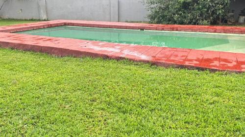 a swimming pool in a yard with green grass at Mercy Guesthouse in Thohoyandou
