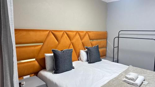 a bedroom with a bed with an orange headboard at Mercy Guesthouse in Thohoyandou