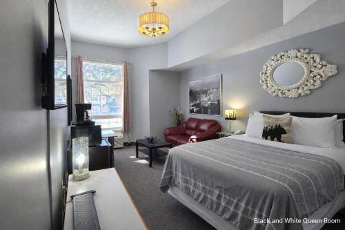 a bedroom with a bed and a chair and a mirror at Mountain View Inn in Canmore