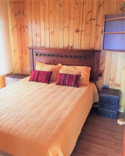 a bedroom with a large bed with wooden walls at Cabaña a pasos del mar in El Cerrillo