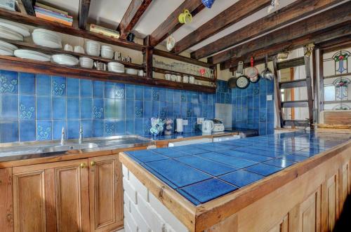 a kitchen with blue tiled walls and a counter top at 3 Bed in Llanfairpwllgwyngyll oc-wai194 in Dwyran