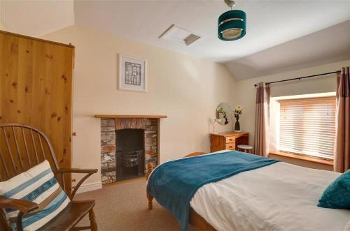 a bedroom with a bed and a fireplace at 3 Bed in Southerndown oc-way216 in Southerndown