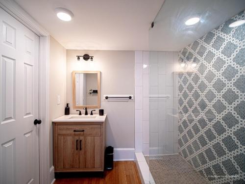 a bathroom with a shower and a sink and a mirror at Oak and Ember at Marietta Square in Marietta