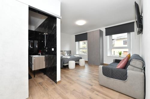a living room with a couch and a television in a room at Mondeo B&B in Udine