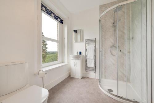 a white bathroom with a shower and a toilet at 5 Bed in Llandovery oc-bow323 in Llangadog