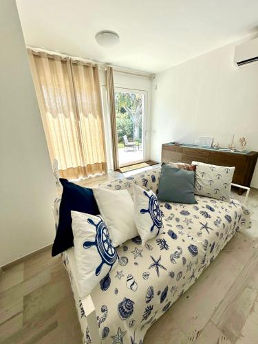a living room with a couch with blue and white pillows at Aquarium - Villa con accesso al mare - parcheggio in San Vito