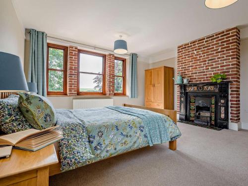 a bedroom with a bed and a fireplace at 4 Bed in Bude oc-ssham in Stratton