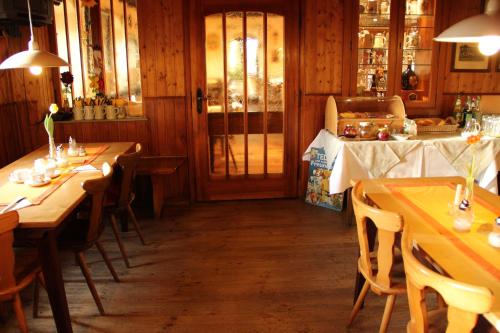 a dining room with wooden tables and chairs at Gasthof Zur Post in Schwabhausen bei Dachau