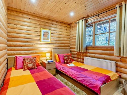 a bedroom with two beds in a log cabin at 3 Bed in Dunsyre oc-lk15m in Walston
