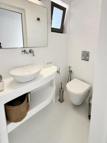 a white bathroom with a sink and a toilet at Sunwave Mykonos Villa in Mykonos
