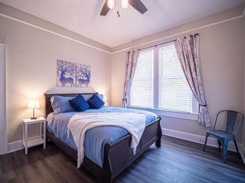 a bedroom with a bed and a chair and a window at Marietta Square's Home Away! in Marietta