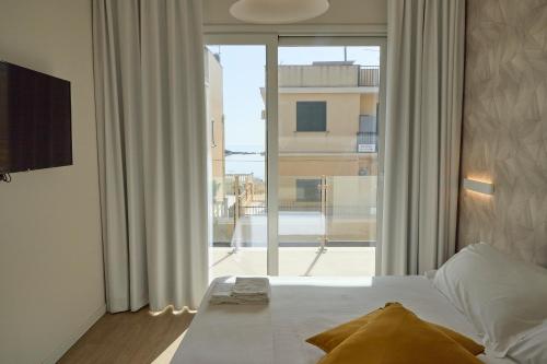 a bedroom with a bed and a large window at Room45 in Marzamemi