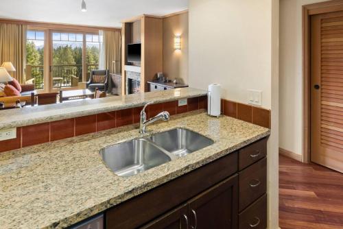 a kitchen with a sink and a living room at 5058 - Grand Suncadia Mountain Lodge with Hot Tub and Views in Cle Elum