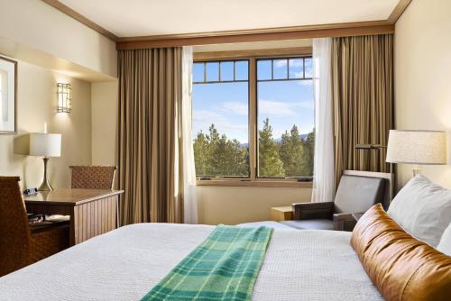 a hotel room with a bed and a desk and a window at 5058 - Grand Suncadia Mountain Lodge with Hot Tub and Views in Cle Elum
