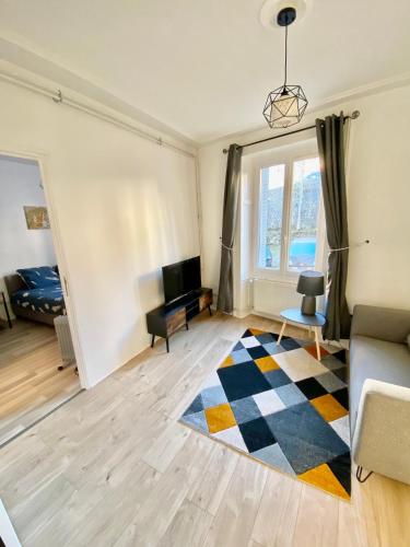 a living room with a couch and a television at Charmant 3 pièces in Saint-Claude