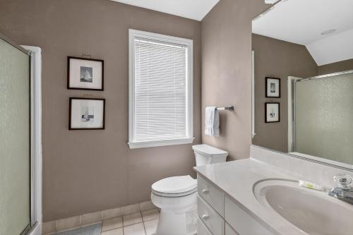 a bathroom with a toilet and a sink and a tub at 221 Olive Way in Saint Simons Island