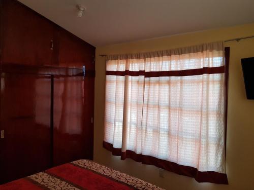 a bedroom with a window with curtains and a bed at Very cute and spacious complete house with a fireplace! in Teziutlán