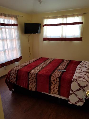 a bedroom with a bed and a flat screen tv at Very cute and spacious complete house with a fireplace! in Teziutlán