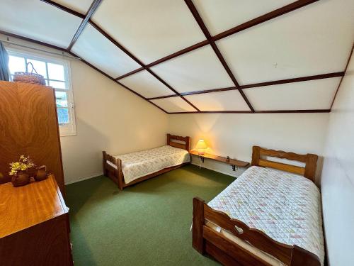 a room with two beds and a ceiling with a window at Apartamento com piscina em Olaria in Nova Friburgo