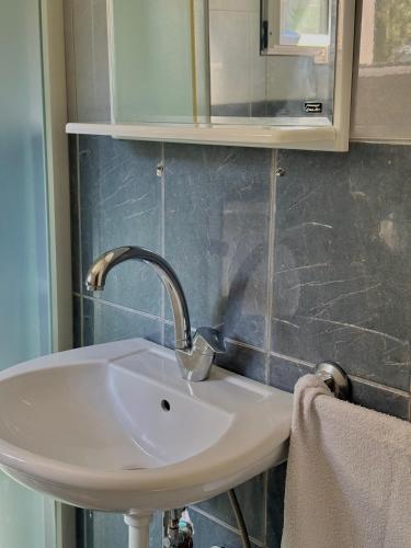 a white sink in a bathroom with a mirror at Radovic Apartmani in Herceg-Novi