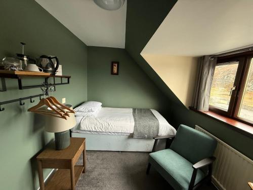 a small bedroom with a bed and a chair at Dunan Hotel in Breasclete