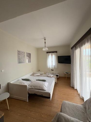 a room with three beds and a flat screen tv at Olea House in Elia Laconias