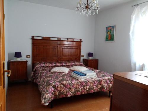 a bedroom with a bed with a wooden headboard at Uliveto in Sulzano
