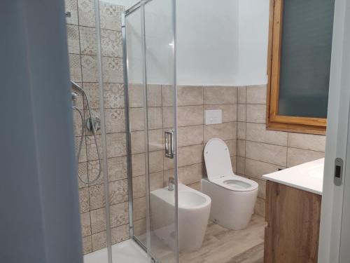 a bathroom with a toilet and a glass shower at Tropea's green terrace in Tropea