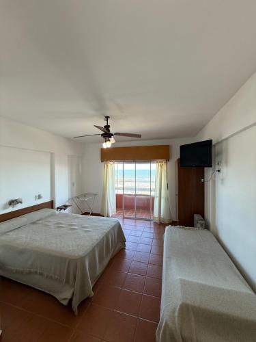 a bedroom with two beds and a flat screen tv at Departamentos Li-Del in Monte Hermoso