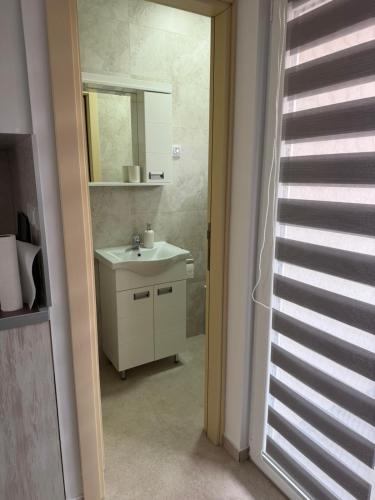 a bathroom with a sink and a mirror at Apartmani Preradović in Pančevo