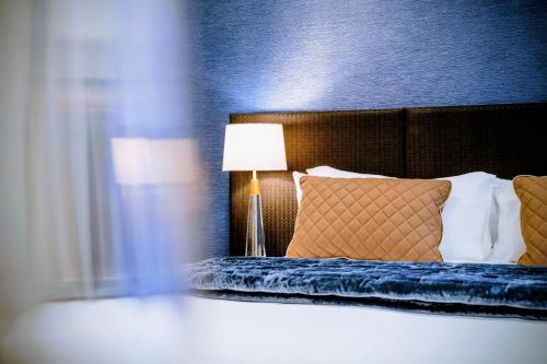 a bedroom with a bed with a blue wall at Gilmer Apartment Hotel in Wellington