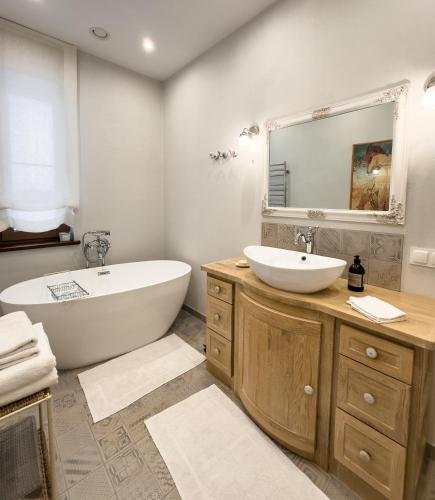 a bathroom with a tub and a sink and a bath tub at Ostoja nad jeziorem Żywki in Żywki