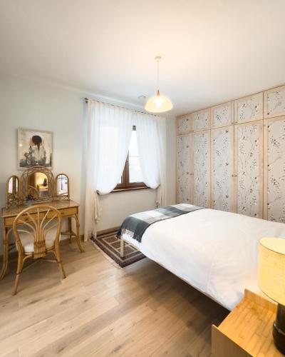 a bedroom with a large white bed and a desk at Ostoja nad jeziorem Żywki in Żywki