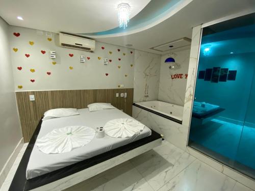 a bedroom with a bed and a shower and a tub at Hotel Suíte in Brasília