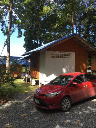 a red car parked in front of a house at Elephant & Castle in Ko Chang