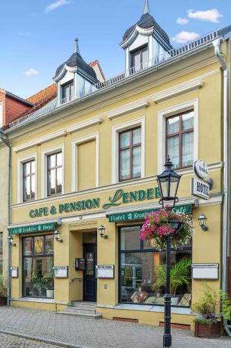 a yellow building with a sign that reads care and permission denominated at Hotel-Pension Lender in Bad Freienwalde