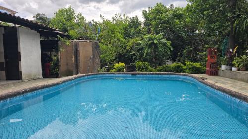 a blue swimming pool in a yard with trees at Hotel Vilcabamba Eterna Juventud in Vilcabamba