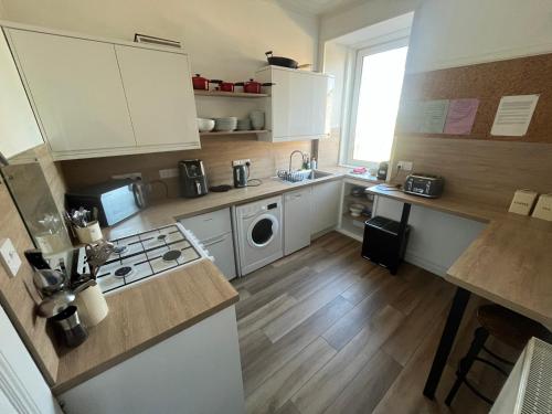 a kitchen with white cabinets and a stove top oven at Period House Auldcastle Road Crown in Inverness