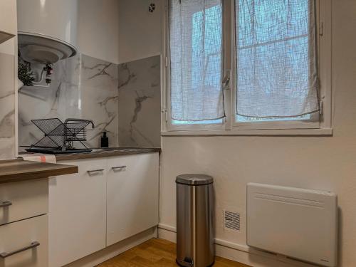 a kitchen with a window and a trash can at Le Michels - Gare - CEA - STMicro in Fontaine