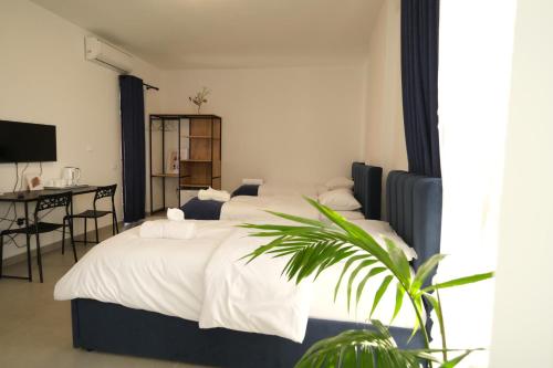 a bedroom with a large white bed and a desk at Bluemoon Retreat in Tirana