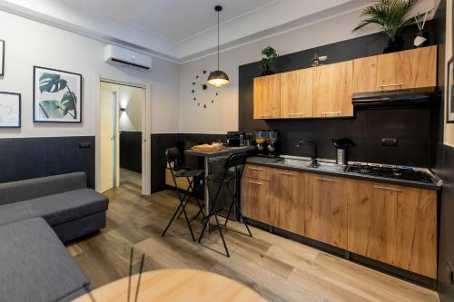 a kitchen with wooden cabinets and a living room at Falco Luxury Home - Naples Airport in Naples