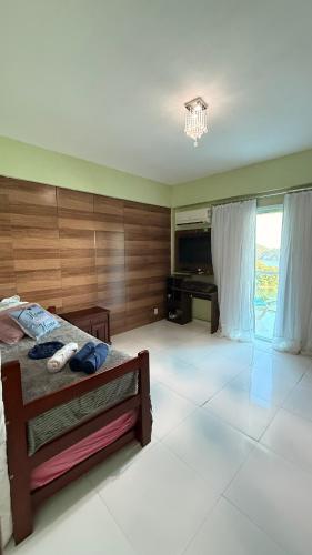 a bedroom with a bed and a television in it at Casa vista infinita in Mangaratiba