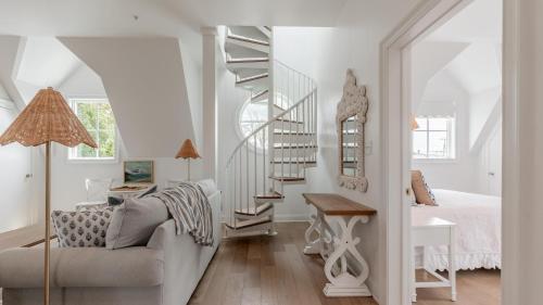 a living room with a spiral staircase and a bedroom at The Ocean Loft At Kings in Cape May