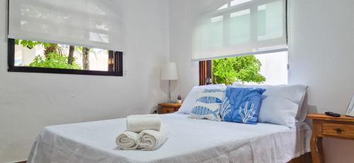 a bedroom with a bed with towels on it at Aloogar Caragua Beach in Caraguatatuba