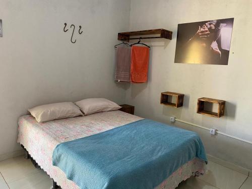 a bedroom with a bed with a blue blanket at COMPARTILHADO Do TERRÃO in Três Marias